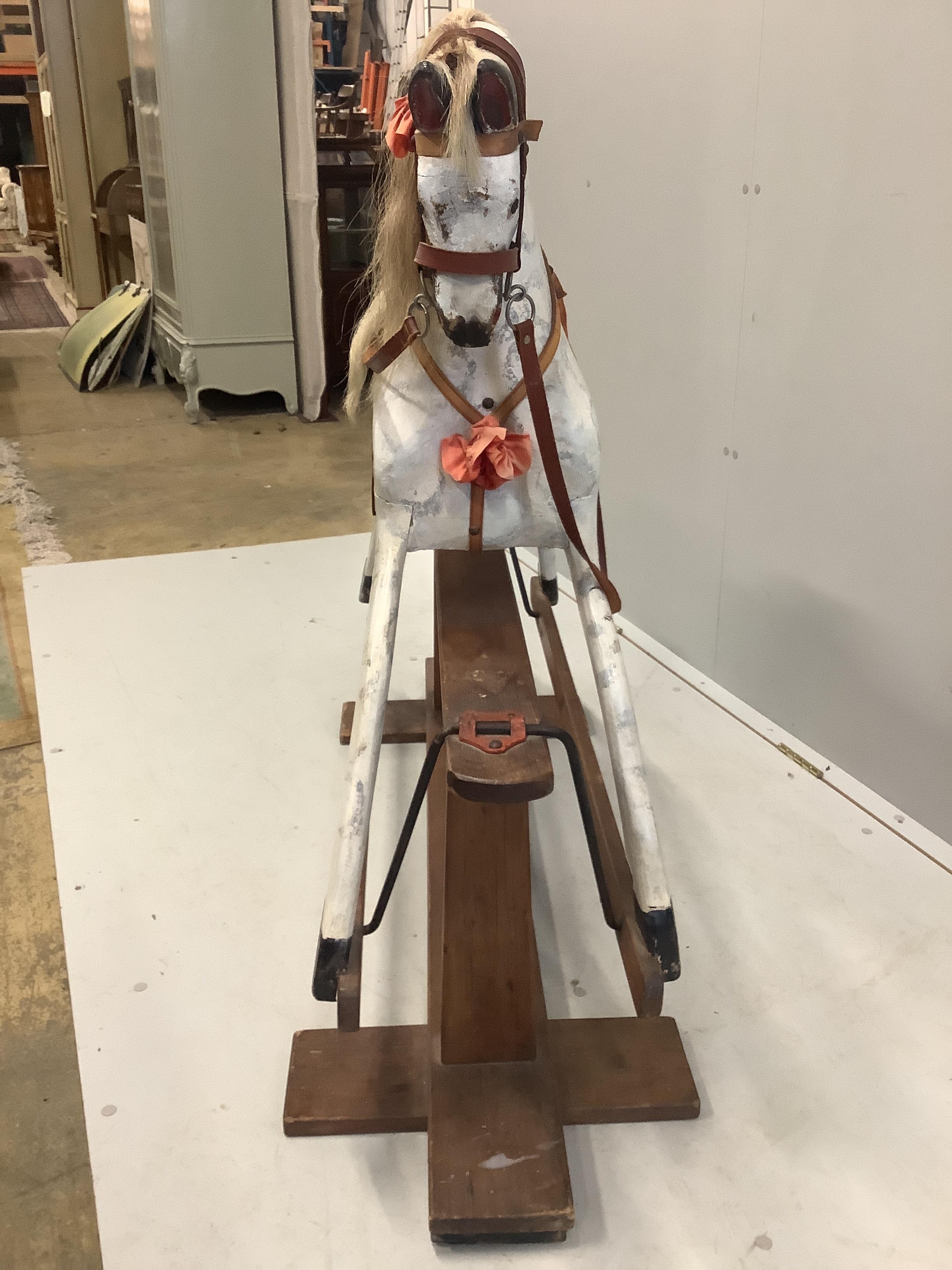 An early 20th century dapple grey rocking horse on pine safety frame, length 130cm, height 106cm